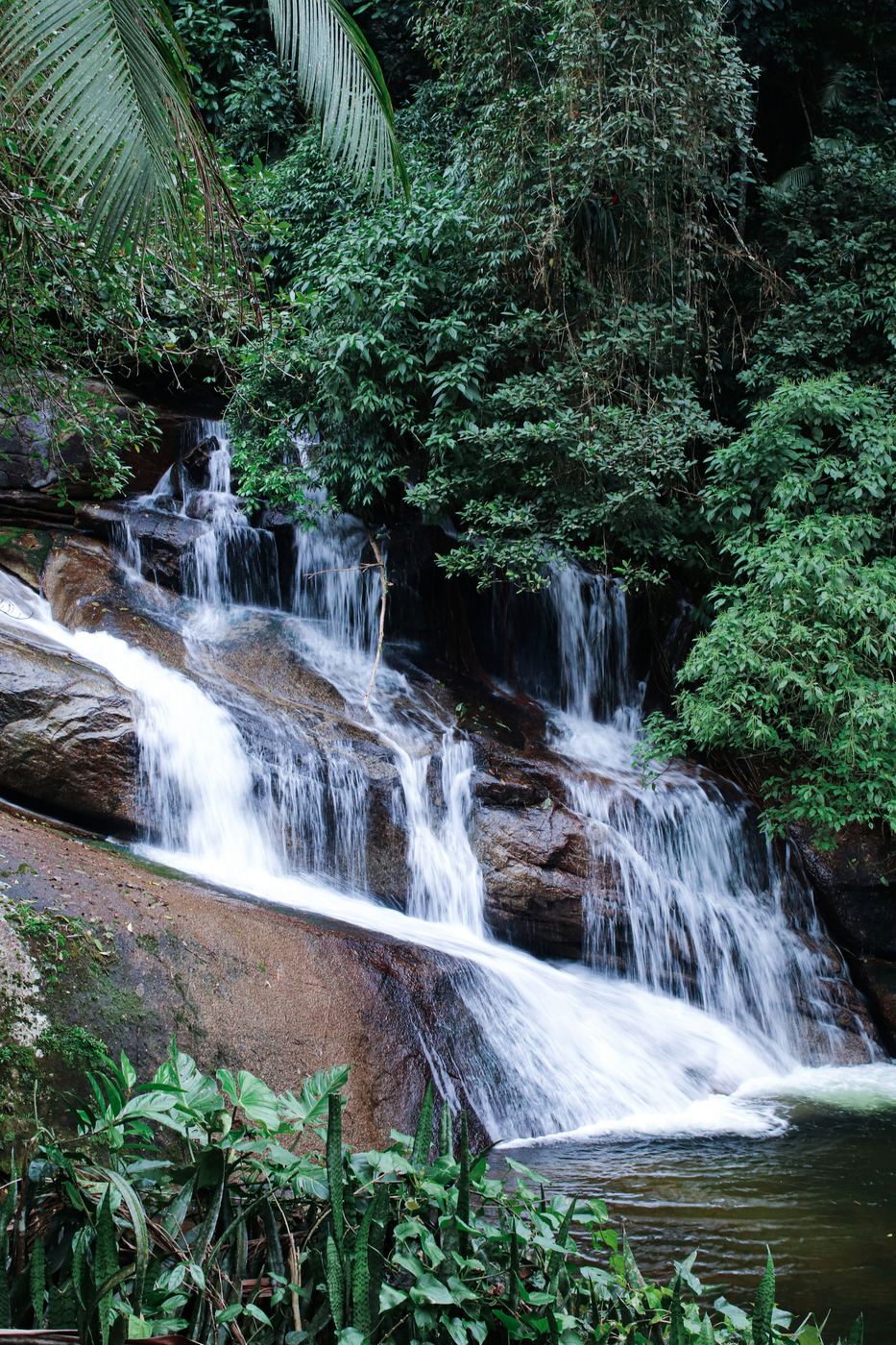 Cachoeira em várias quedas entre pedras e mata