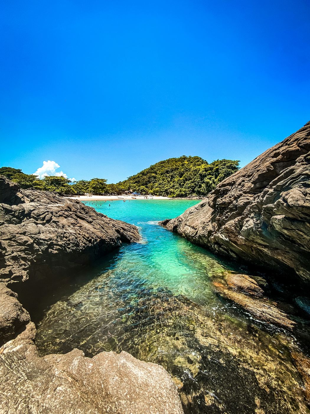 A piscina natural do Cachadaço: água verde-clara entre costões de pedra, em Trindade